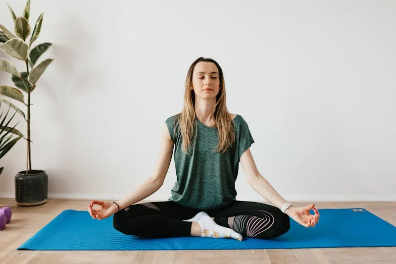 A group of people practice yoga in a sunlit studio.